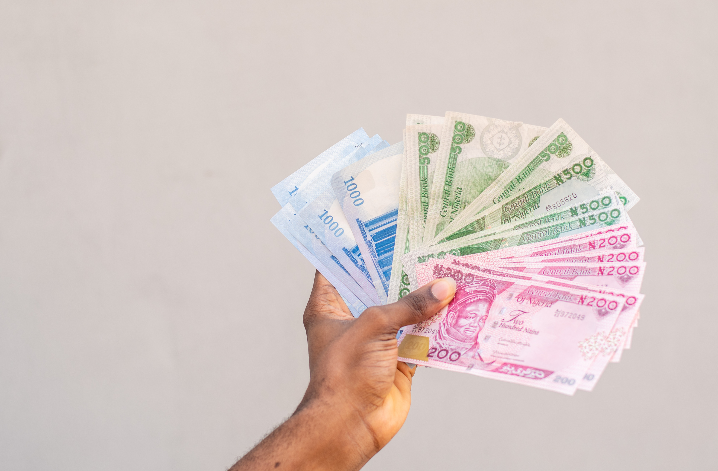 A man holding Nigerian naira notes-uLesson Referral Programme