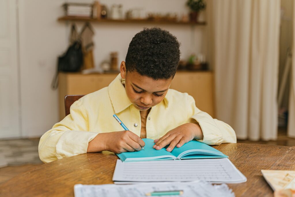 A young boy writing in a book