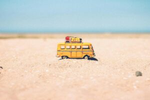 A miniature yellow bus on the sand