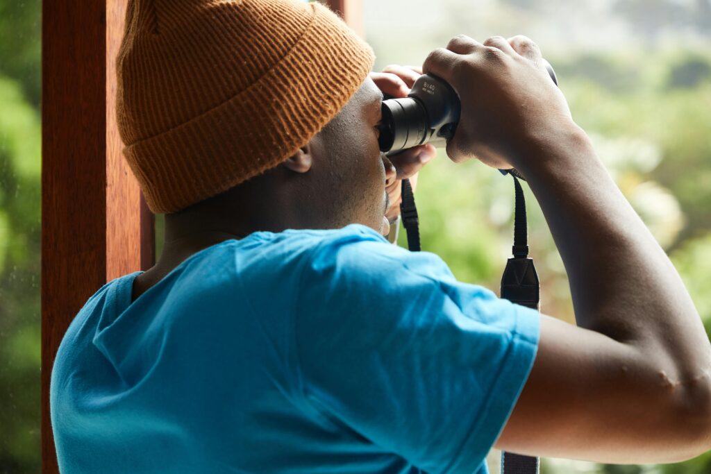 A young man looking through binoculars