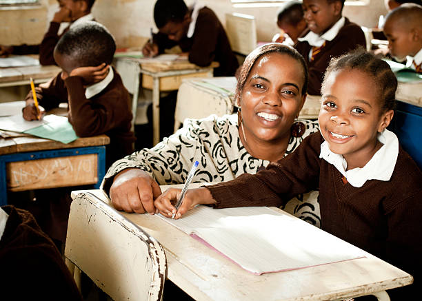 A female teacher and student in a class smiling at the camera