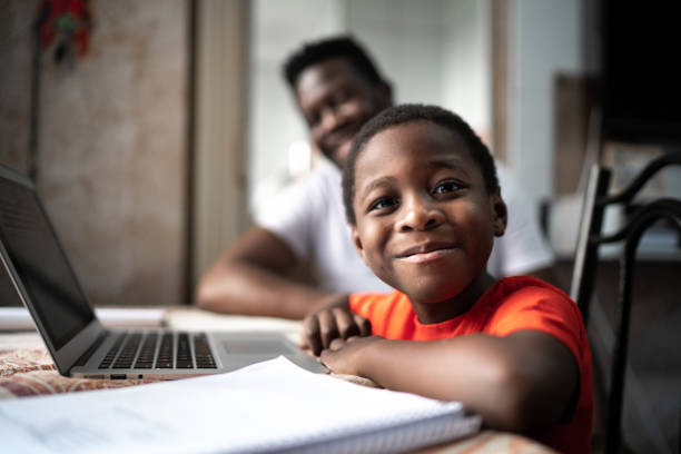 Adult male and young boy at a desk smiling - How to Help Students Address Emotional Challenges