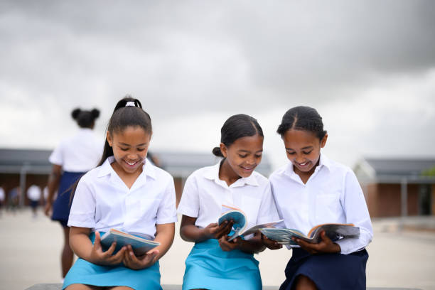 Three school girls studying their textbooks