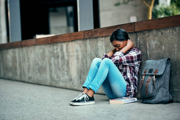 Young female student sitting on the floor dealing with emotional challenges
