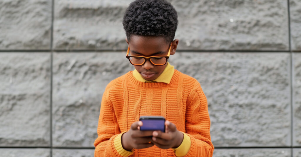 A young boy learning on his smartphone